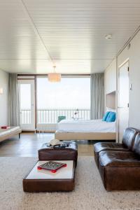 ein Wohnzimmer mit einem Bett, einem Sofa und einem Bett in der Unterkunft Hotel de Milliano in Breskens