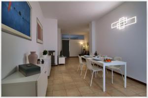 a dining room with a white table and chairs at [10 min metro] Palavela Suite in Turin