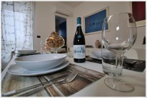 a table with a bottle of wine and a wine glass at [10 min metro] Palavela Suite in Turin