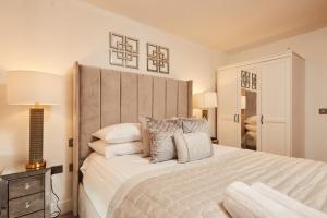 sypialnia z dużym białym łóżkiem z poduszkami w obiekcie Deluxe City Apt Riverside Balcony &Free Parking w mieście Leeds