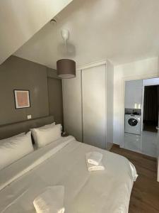 Un dormitorio con una cama blanca con un plato. en Niarchos apartment III, en Atenas
