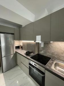 a kitchen with a stove and a stainless steel refrigerator at Niarchos apartment III in Athens