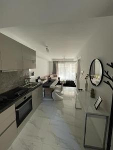 a large white kitchen with a sink and a living room at Niarchos apartment III in Athens