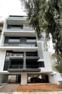 ein weißes Gebäude mit einem davor geparkt in der Unterkunft Niarchos apartment III in Athen