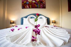 a white bed with a swan made out of flowers at Rico's Patong Hotel in Patong Beach