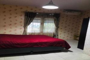 a bedroom with a red bed and a window at EXPRESS O 91923 Homestay Zona in Sukabumi