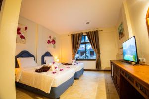sypialnia z 2 łóżkami i telewizorem z płaskim ekranem w obiekcie Rico's Patong Hotel w Patong Beach