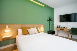 sypialnia z dużym białym łóżkiem i telewizorem w obiekcie Vallecas Suites by Olala Homes w Madrycie