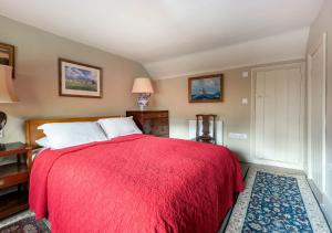 a bedroom with a large bed with a red blanket at The Pightle in Parham