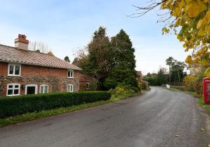 an empty road in front of a brick house at The Pightle in Parham