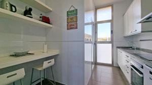 eine weiße Küche mit einer Theke und einem Fenster in der Unterkunft Gran lujo, terraza grande y vistas al mar - planta 41 in Benidorm