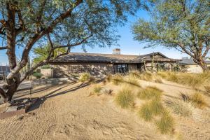 una vieja casa de piedra con árboles delante de ella en Scottsdale Escape en Scottsdale