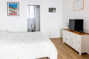 a bedroom with a bed and a tv on a dresser at Studio cosy Pinot Meunier au cœur d'Hautvillers in Hautvillers