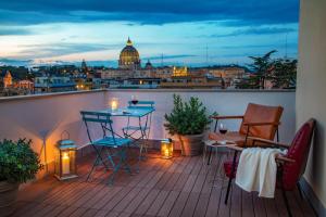 einen Balkon mit einem Tisch und Stühlen sowie Blick auf die Hauptstadt in der Unterkunft Bloom Hotel Rome in Rom