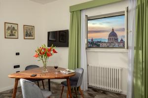 ein Esszimmer mit einem Tisch und Blick auf die Kuppel in der Unterkunft Bloom Hotel Rome in Rom