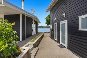 a house with a walkway next to a building at Habourside - Ohope Holiday Home in Ohope Beach