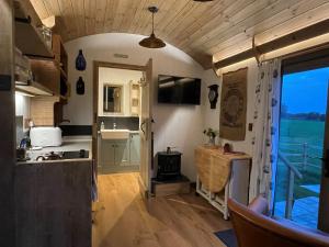 una cucina e un soggiorno in una casetta minuscola di The Huddle at Big Sky Brisley a Brisley