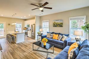 un salon avec un canapé bleu et une table dans l'établissement Modern Candler Home with Deck and Yard!, à Asheville