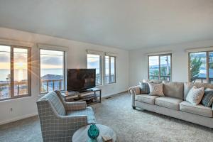 a living room with a couch and a tv and windows at Pet-Friendly Cayucos Home with Ocean Views! in Cayucos