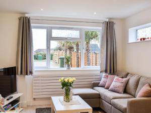 a living room with a couch and a window at Lamorna in Littlehampton