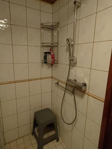 un bagno piastrellato con doccia e sgabello. di Villa Bear's a Rovaniemi