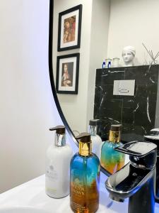 una mesa con tres botellas de jabón y un espejo en AD Boutique Apartment, en Budapest