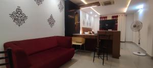 a living room with a red couch and a desk at Happy Vibes Nest-studio flat in Vānivilāsa Puram