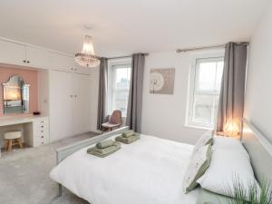 a bedroom with two beds and a desk and windows at Lark's Nest in Scarborough