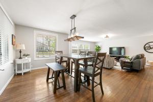 een eetkamer en een woonkamer met een tafel en stoelen bij Central Bike Cottage in Bentonville