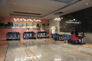 a lobby with tables and chairs and people sitting at them at THE CRUZE PREMIUM BOUTIQUE HOTEL in Jamshedpur