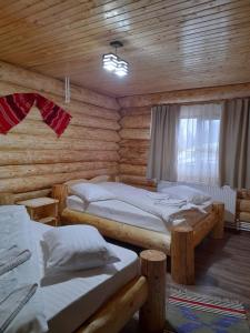 En eller flere senge i et værelse på Cabana Colț De Munte
