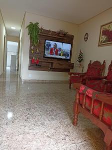 a living room with couches and a flat screen tv at Casa a 5 minutos a pé da Basílica e da feira em Aparecida in Aparecida