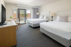 a hotel room with two beds and a flat screen tv at The Lodge at Tiburon in Tiburon