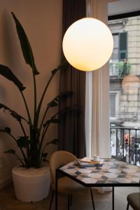une table avec une lampe et une plante en pot dans l'établissement Mirabilis Relais, à Naples