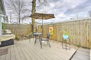 a patio with a table and chairs and an umbrella at Belmar Cottage with Deck and Fire Pit! in Belmar