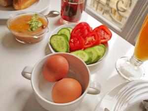 a table with eggs and vegetables and a bowl of soup at Travelers House in Cairo