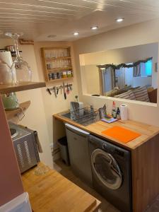 uma cozinha com uma máquina de lavar roupa e um balcão em Hideaway@no3 em Thornton Dale