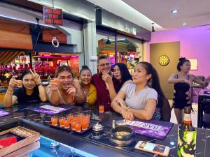 a group of people sitting at a bar at Barzilla Bar And Guesthouse in Pattaya