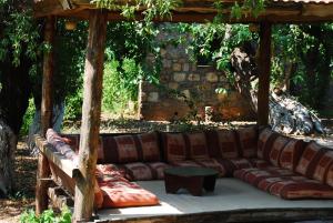 a large couch sitting under a wooden pergola at Doga Apartments in Kayakoy