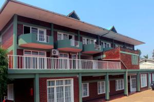 a large red brick building with a balcony at MOUCECORE in Kigali