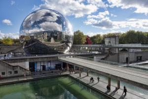 - un bâtiment en forme de dôme avec une piscine d'eau et des personnes qui s'y promenent dans l'établissement Ibis Styles Paris Crimée La Villette, à Paris