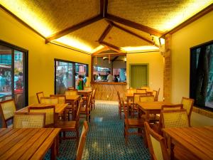 un restaurante vacío con mesas y sillas de madera en Buzios Espiritualidade Hotel, en Búzios