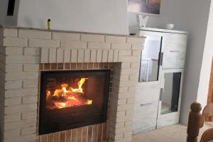 a brick fireplace with a fire in it at Casa Gracia in Sacedón