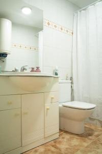 a white bathroom with a toilet and a sink at Casa Gracia in Sacedón