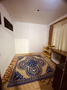 Habitación con alfombra azul y blanca en el suelo en Pondok Muara Chalet, en Pantai Cenang