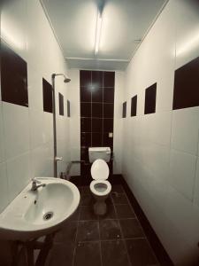 La salle de bains est pourvue de toilettes blanches et d'un lavabo. dans l'établissement Pondok Muara Chalet, à Pantai Cenang