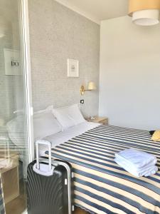 una camera d'albergo con un letto e una valigia di Hotel Riviera a Lido di Jesolo