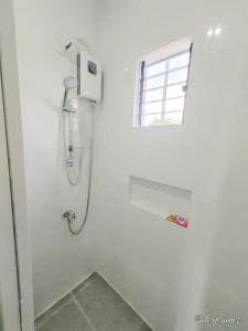 a shower in a white bathroom with a window at Palm View Moalboal in Moalboal