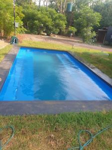 a large blue swimming pool in the grass at Vulture's View 6 in Hartbeespoort +35 photos