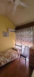 1 dormitorio con 1 cama, 1 silla y 1 ventana en HERMINIA en Villa Carlos Paz